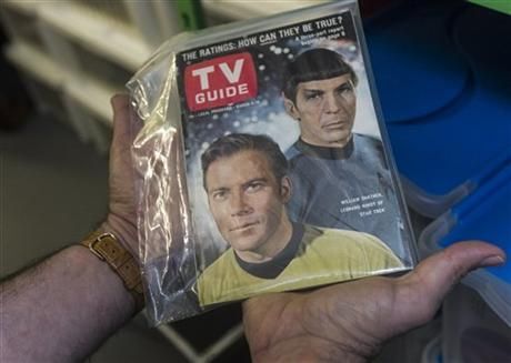 In this Friday, Nov. 30, 2012 photo, James Comisar holds an original TV Guide issue featuring William Shatner, and Leonard Nimoy of "Star Trek." The item is part of his television memorabilia collection in a temperature- and humidity-controlled warehouse in Los Angeles.
