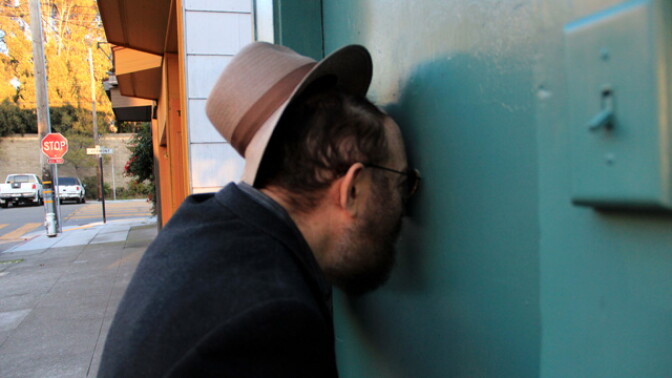 A man looks in the peephole at Savernack Street.