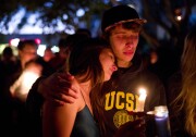Two students comfort each other during a candlelight vigil held to honor the victims of Friday night's mass shooting on Saturday, May 24, 2014, in Isla Vista, Calif. Sheriff's officials said Elliot Rodger, 22, went on a rampage near the University of California, Santa Barbara, stabbing three people to death at his apartment before shooting and killing three more in a crime spree through a nearby neighborhood. (AP Photo/Jae C. Hong)