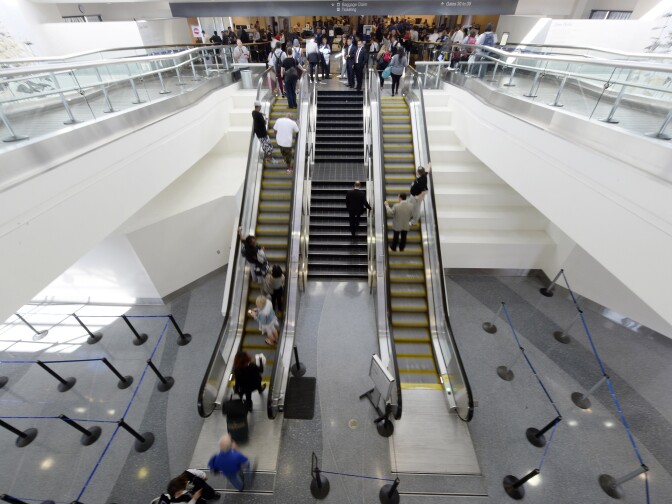 Travelers approach the security screening after Terminal 3 was re-opened a day after a shooting at Los Angeles International Airport November 2, 2013 in Los Angeles, California. The airport is almost back to normal operations 2 days after a man pulled out an assault rifle and shot his way through security at Terminal 3, killing one Transportation Security Administration worker and wounding several others. Federal officials identified the alleged gunman as Paul Ciancia, 23.  