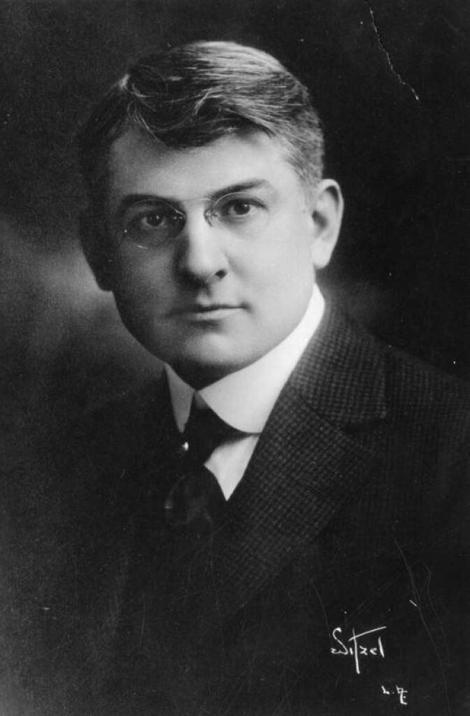 A black and white archival photograph of Everett Perry, a white man wearing a suit and tie.