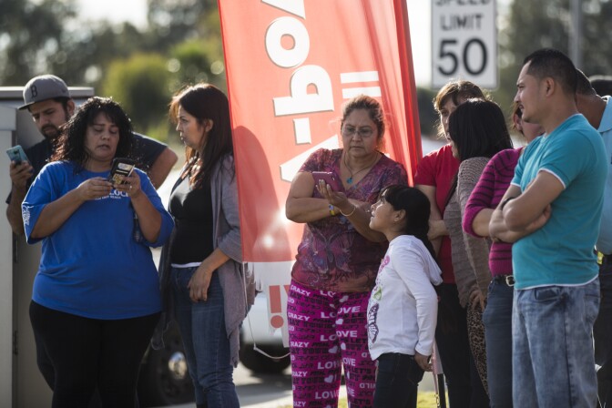 Local residents gather at East Orange Show Road and South Waterman Avenue near the Inland Regional Center in San Bernardino after a mass shooting on Wednesday, Dec. 2, 2015.