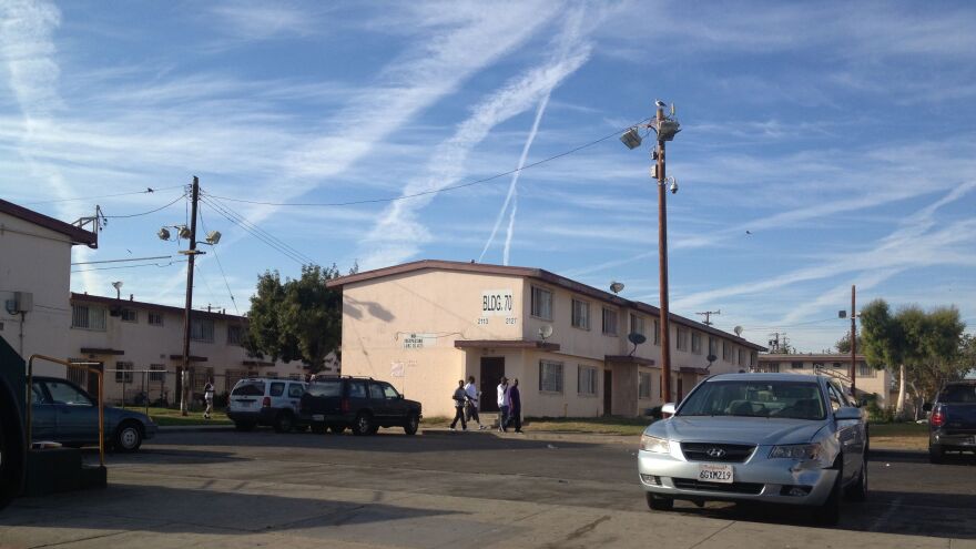 LAPD officers watch the pedestrian traffic at Jordan Downs public housing to make sure crowds don't get out of hand. 