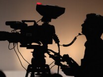 A silhouette of a camera operator shooting film. File photo. 