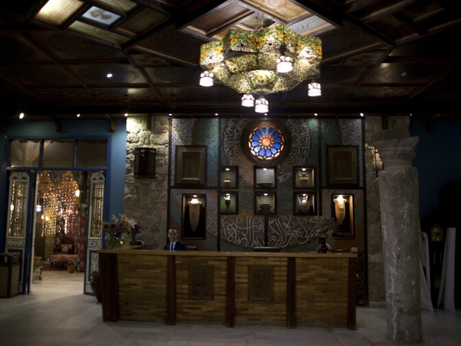 An employee sits behind the reception desk of Al-Mathaf Hotel in Gaza City, in 2019.