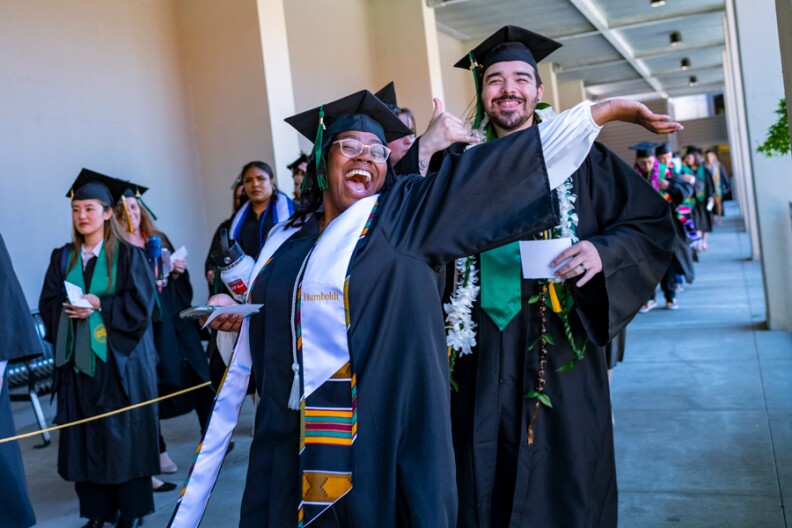 A Black woman in graduation clothes celebrates her graduation.
