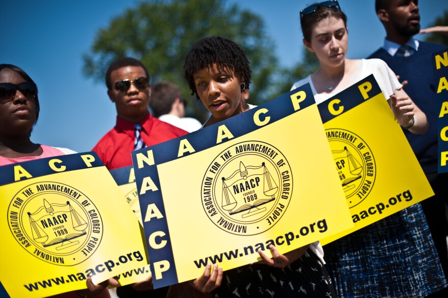 Members of the National Association for the Advancement of Colored People (NAACP) hold signs in front of the US Supreme Court in Washington on June 25, 2013. The court struck down a key part of the Voting Rights Act, which guards against racial discrimination in US states with a segregationist past. In a hotly anticipated decision, the court ruled 5-4 that Section 4 of the 1965 law was unconstitutional, calling on Congress to redefine which states must seek government approval for changes to their electoral codes.