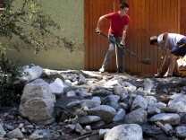 Zavier Slaght, 16, left, and Justin Gronek, 18, of Highland help dig out a friend's cabin in Forest Falls two days after a mudslide buried the community in boulders and debris.