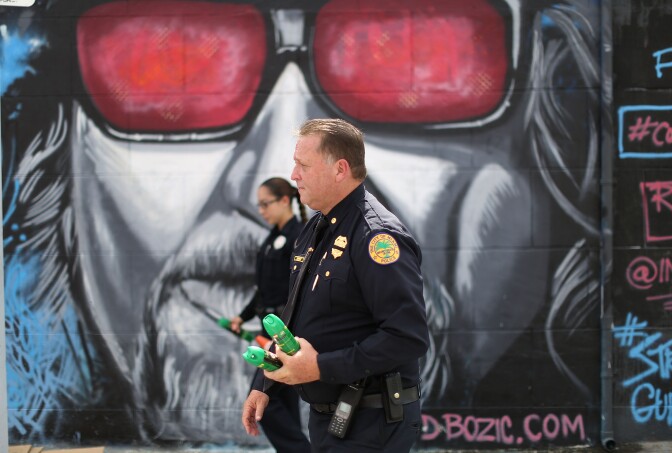 MIAMI, FL - AUGUST 02:  James Bernat and Michelle Albelo, City of Miami police officers, give out cans of insect repellent as they help people near the Miami Rescue Mission prevent mosquito bites that may infect them with the Zika virus on August 2, 2016 in Miami, Florida.  A reported 14 individuals have been infected with the Zika virus by local mosquitoes.  (Photo by Joe Raedle/Getty Images)