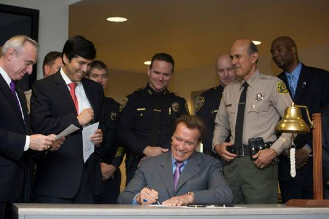 Governor Schwarzenegger signs into law a bill restricting ammunition sales.  Democratic State Assemblyman Kevin DeLeon (left) of Los Angeles authored the legislation.