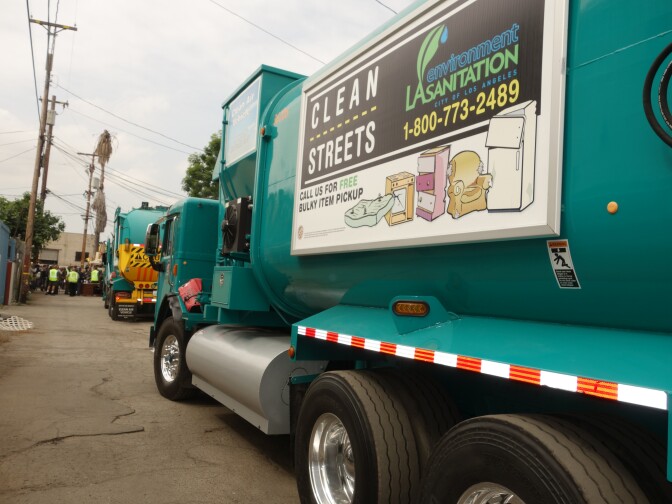 Los Angeles city Bureau of Sanitation garbage truck with billboard advertising free bulky item pickup service.