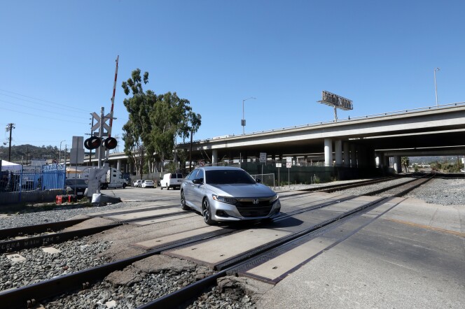 A silver car drives over the Doran Street train crossing in Glendale. 
