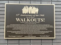 A brown and gold frame plaque with a description of the East L.A Walkouts. 