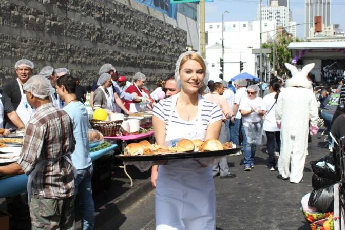 A woman carries meals to guests at the Midnight Mission's Easter Brunch in downtown Los Angeles in 2015.