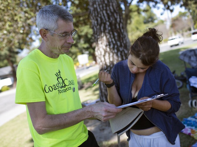 Volunteer Philip Armstrong, left, works with Julia Lewis, 20, during a weekly outreach assessment put on by the Coast to Coast Foundation in partnership with the Fullerton Police Department on Thursday, March 5, 2015 at Pacific Drive Park. Lewis is from New Jersey and has been homeless in Orange County for four years.