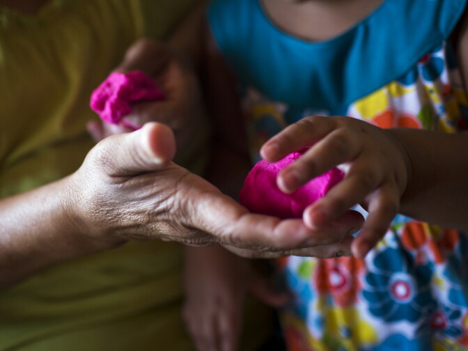 Maria Garcia hands Play-Doh to her granddaughter, Soledad Garcia, 3, on Monday afternoon, August 3, 2015. A large number of children in South Los Angeles are not living with their parents, sometimes due to addiction issues or incarceration.