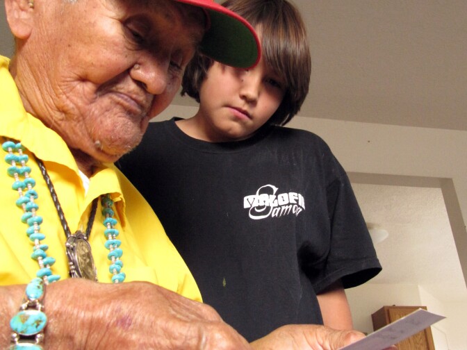 This Nov. 29, 2009 photo shows Navajo Code Talker Chester Nez looking at at an old photo with his grandson peering over his shoulder at their Albuquerque N.M. 