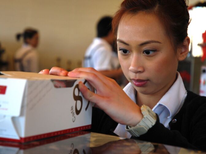 WEST COVINA, Calif. -- Sophia Almendrala, local resident and bakery employee, boxes a cake for a customer at the new 85°C Bakery Cafe on Jan. 16. This company-owned West Covina location is the third to open in the United States, with more openings planned throughout Southern California. The Taiwan-based chain, while new to the U.S. market, operates more than 700 stores worldwide.