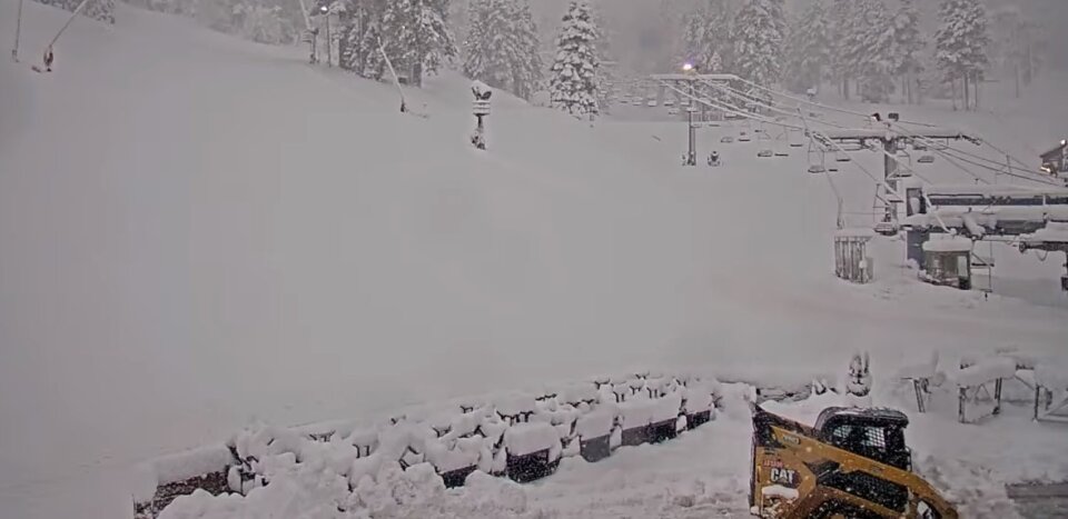 Heavy snow buries trees and the ground under a ski lift