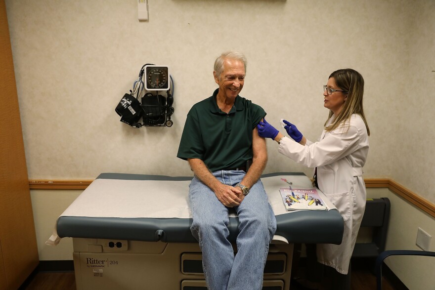 MIAMI, FL - OCTOBER 04: Stuart Goldstein receives an influenza vaccination from nurse practitioner, Katherine Male, at the CVS Pharmacy store's MinuteClinic on October 4, 2018 in Miami, Florida. CVS stores will provide flu vaccinations at their MinuteClinic as well as the pharmacy and according to the Centers for Disease Control and Prevention and the American Academy of Pediatrics between now and the end of October is the best time to get vaccinated as the flu season begins.  (Photo by Joe Raedle/Getty Images)