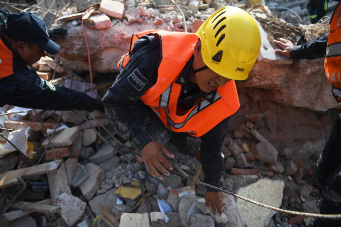A member of the Federal Police's rescue team searches for survivors in Juchitan de Zaragoza, Mexico, on September 9, 2017 after a powerful earthquake struck Mexico's Pacific coast.