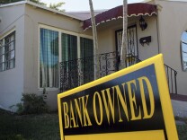 A bank-owned sign is seen in front of a foreclosed home in Miami. Florida was among the hardest hit states in the real estate collapse.