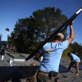 SAN RAFAEL, CA - FEBRUARY 26:  SolarCraft worker Joel Overly carries a solar panel on the roof of a home on February 26, 2015 in San Rafael, California. According to a survey report by the Solar Foundation, the solar industry employs more workers than coal mining with nearly 174,000 people working in solar compared to close to 80,000 mining coal.  (Photo by Justin Sullivan/Getty Images)