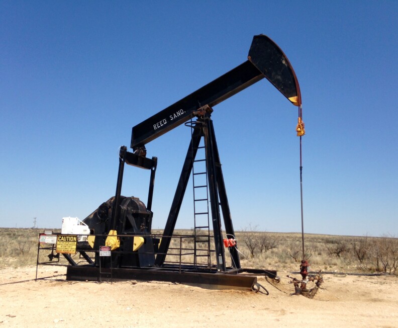 An older vertical pump jack sucks up crude oil outside Hobbs, New Mexico.
