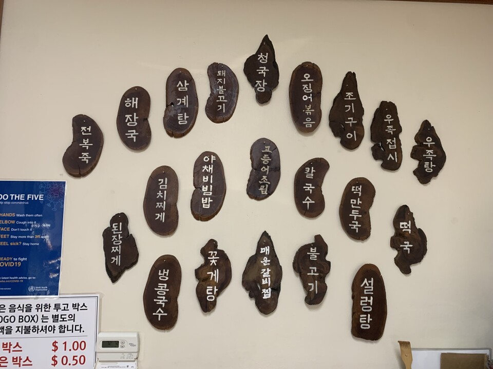 An image of a wall of menu items inscribed on wooden tablets at the Olympic Restaurant in Koreatown. 