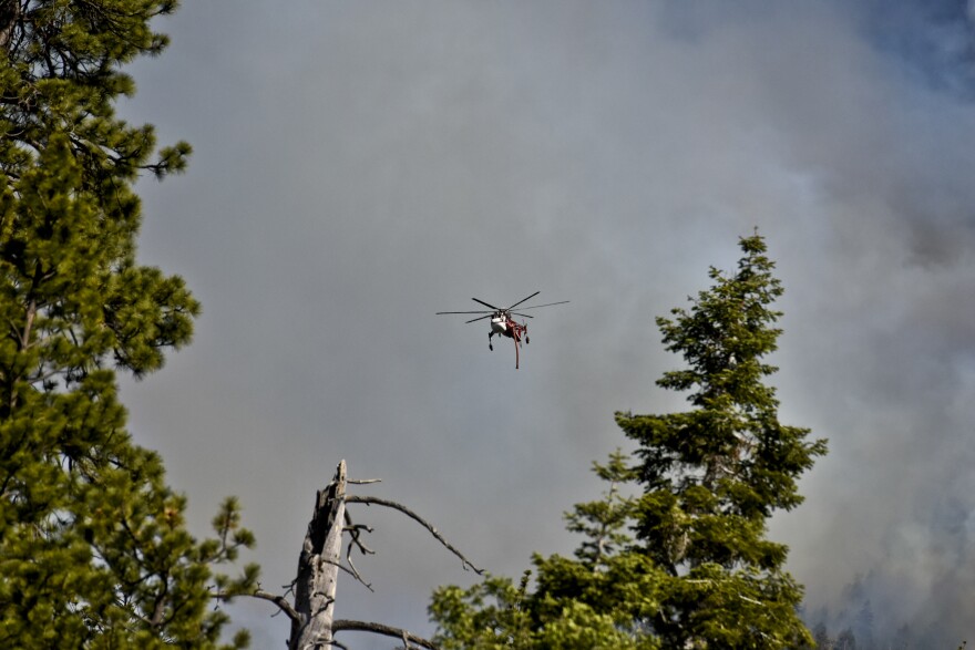 A helicopter flies over the Lake Fire Thursday afternoon off Jenks Lake Road in the San Bernardino National Forest. 