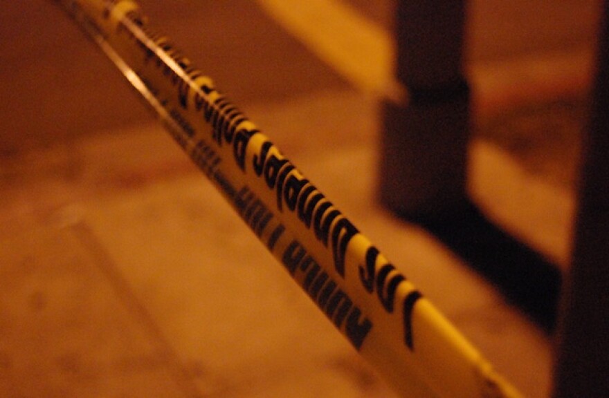 LAPD police tape stretches across a sidewalk at night.