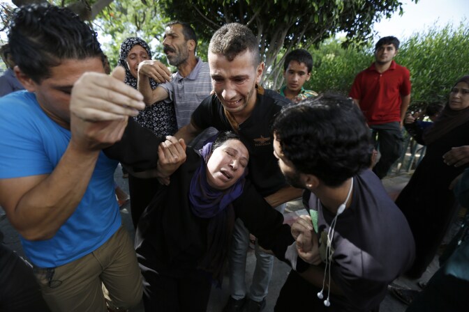 The mother of one of the four boys, all from the Bakr family, killed during Israeli shelling, collapses outside the al-Shifa hospital in Gaza City, on July 16, 2014.