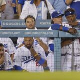 Members of the Los Angeles Dodgers watch from the dugout during the ninth inning of their baseball game against the San Francisco Giants, Tuesday, Oct. 2, 2012, in Los Angeles. The Giants won the game 4-3. With that loss, the Dodgers were eliminated from playoff contention. (AP Photo/Mark J. Terrill)