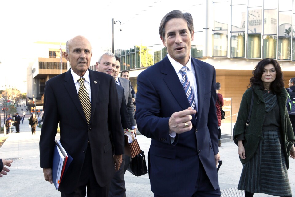Former Los Angeles County Sheriff Lee Baca, left, his attorney Nathan Hochman, center, and Baca's wife Carol leave federal court in Los Angeles, Monday, Dec. 19, 2016, after the prosecution and defense presented their closing arguments and the case went to the jury.