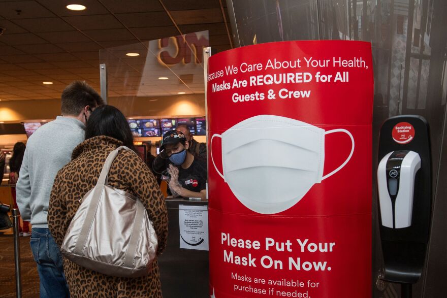 A sign asking people to wear a mask is displayed as moviegoers buy tickets at the AMC Burbank theatre on reopening day in Burbank, California, March 15, 2021. - Los Angeles and southern California is allowed to partially reopen indoor dining and movie theaters Governor Gavin Newsom announced last week, as the region hit key health criteria.
Slammed by a brutal Covid-19 pandemic winter spike, California has seen a rapid decline in infection rates in recent weeks as a vaccination rollout has delivered at least one dose to nearly a fifth of residents. (Photo by VALERIE MACON / AFP) (Photo by VALERIE MACON/AFP via Getty Images)