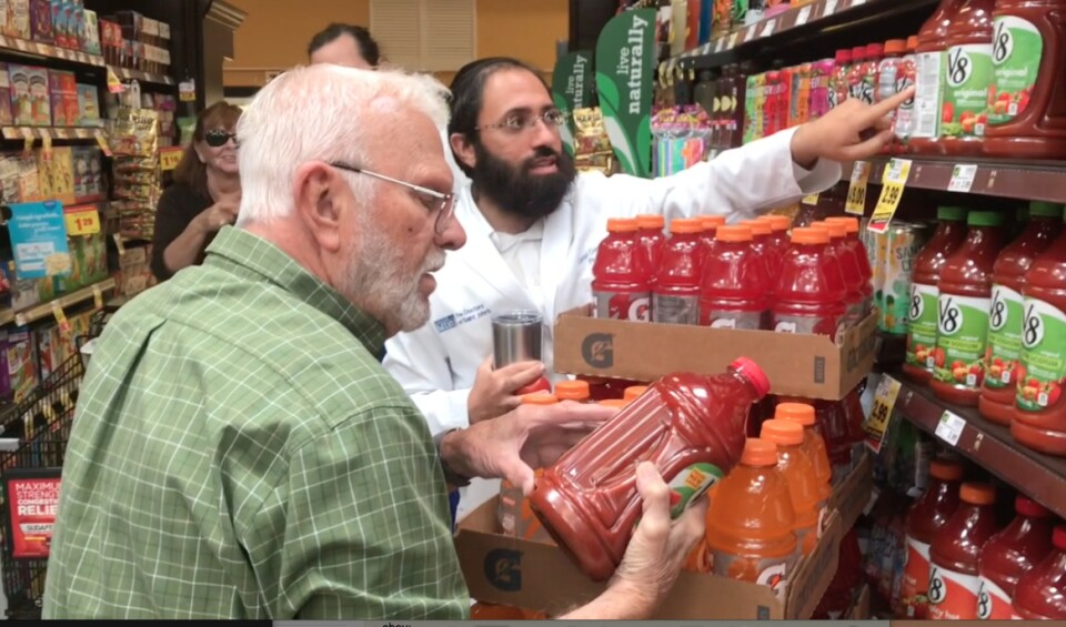 Dr. Daniel Ganjian talks shopper Richard Cook into trying the low-sodium vegetable juice. 