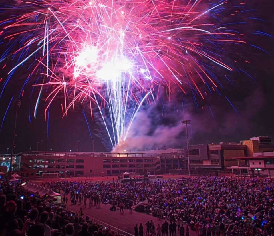 Fireworks are seen lighting up the night sky over Santa Monica College as a crowd watches. 