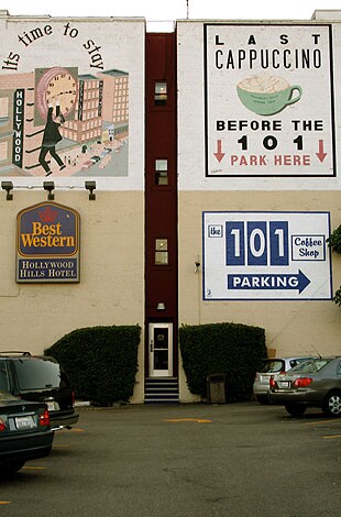 View of the side of Cafe 101 building with a Best Western sign