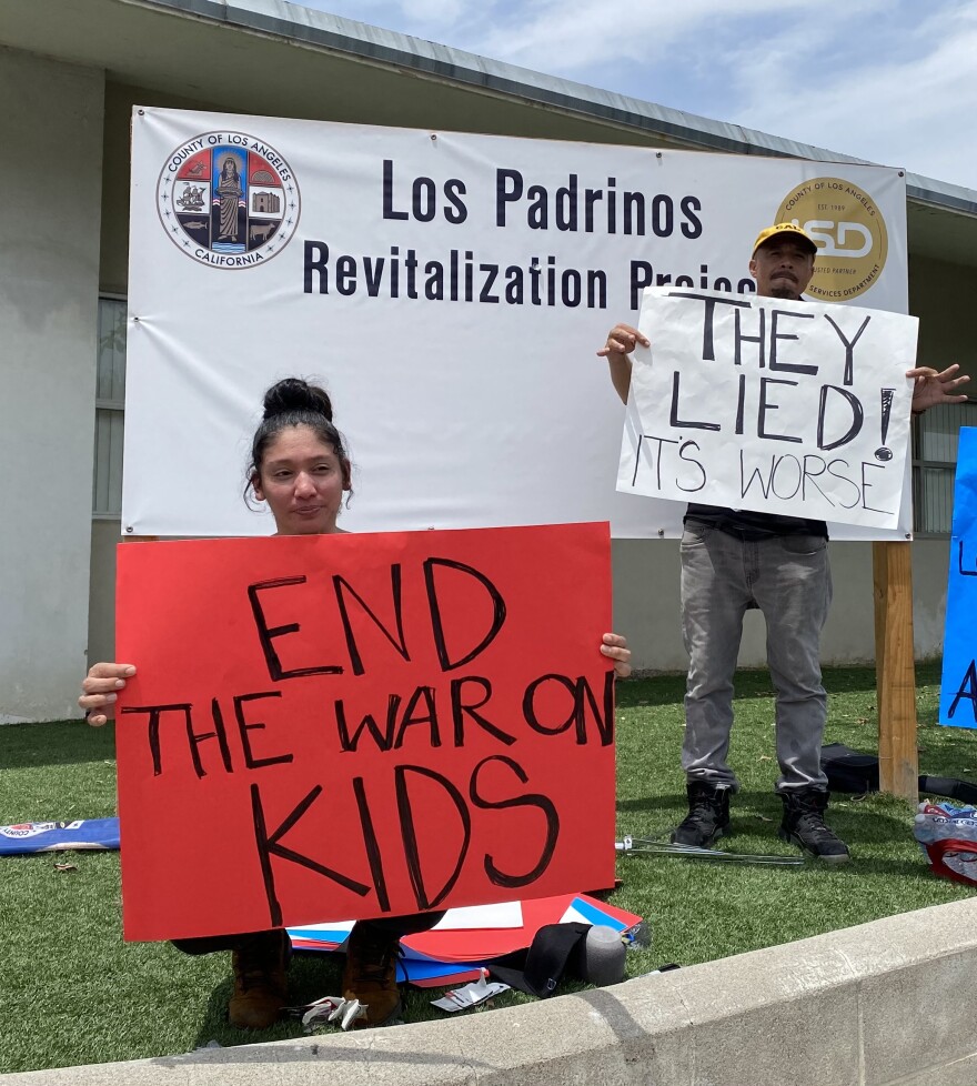 A protester holds a sign that reads "End the War on Kids"