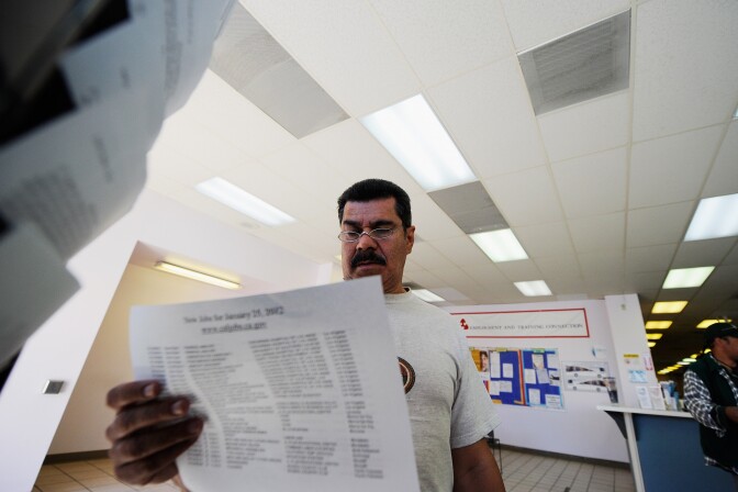 George Hernandez looks at job openings at the Foothill Employment and Training Connection in Pasadena earlier this year. The Labor Department said Thursday that the number of Americans seeking unemployment benefits jumped by 16,000 last week, the second straight weekly increase, But the longer-term trend in layoffs remained consistent with an improved job market.
	
