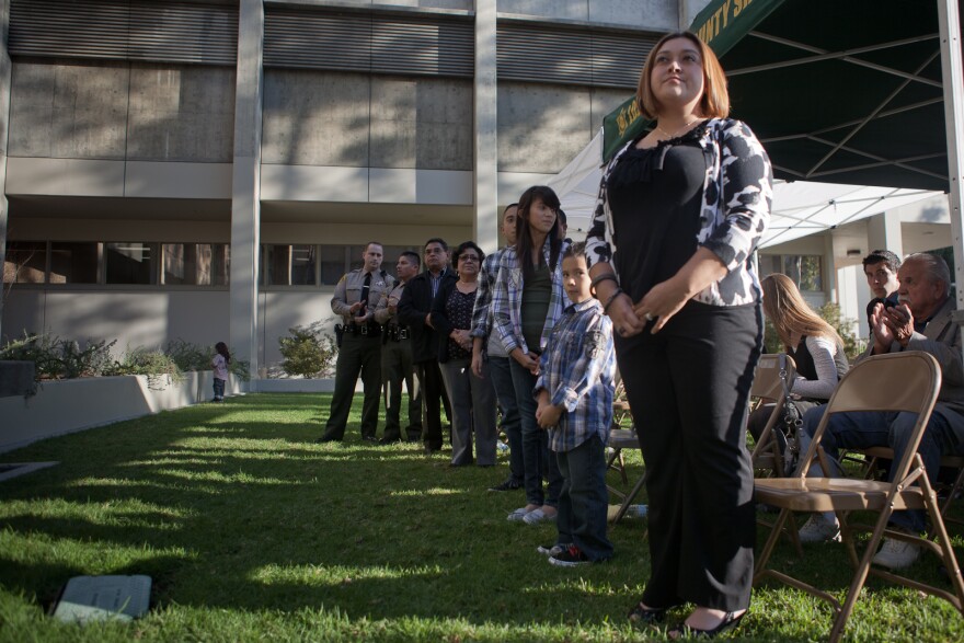 The widow of slain county sheriff's officer Juan Escalante looks on at a memorial ceremony for her husband who lost his life when he was shot by a gang member outside his home in 2008.