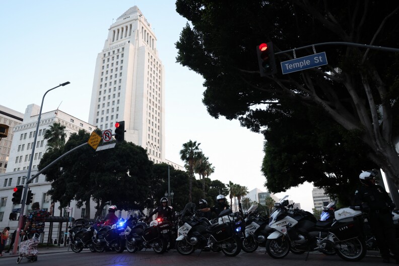 LAPD officers block a street in front of Los Angeles City Hall as curfew goes into effect in downtown Los Angeles, on June 12, 2025.