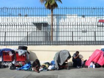 Homeless women sit amid their belongings in downtown Los Angeles on Jan. 1, 2014.