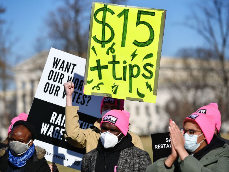 An activist holds a placard demanding a $15 per hour minimum wage and tips for restaurant workers during a rally at the House Triangle of the US Capitol in Washington, D.C. on Feb. 8.