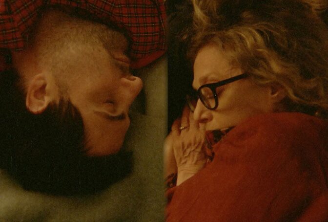 Two people sleep across from each other on a couch 