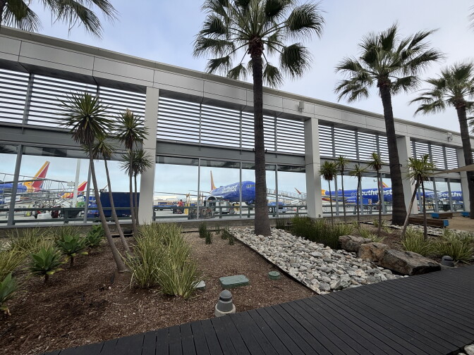 Southwest Airlines planes are parked on a tarmac outside a passenger terminal