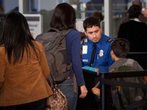 A Transportation Security Administration (TSA) official scans travelers at Terminal Five of John F. Kennedy Airport on December 23, 2011 in New York City. Port Authority of New York and New Jersey predicted that John F. Kennedy Airport would be used by 1.9 million travelers over the holiday season.  