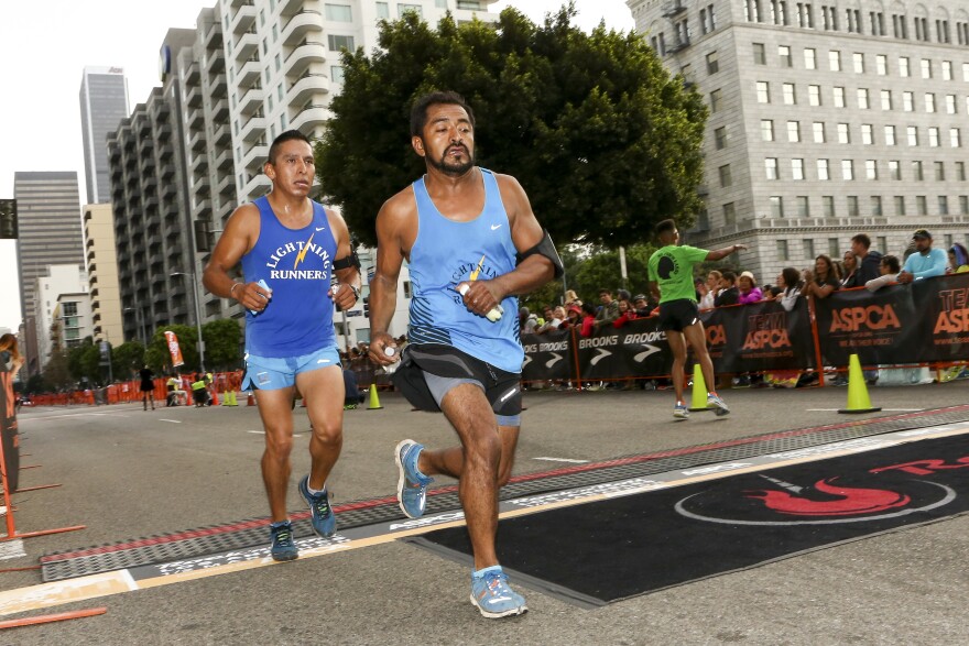 Runners prepare to cross the finish line at the Rock 'n' Roll Los Angeles Halloween Half-Marathon and 5K on October 26, 2014 in Los Angeles, California.