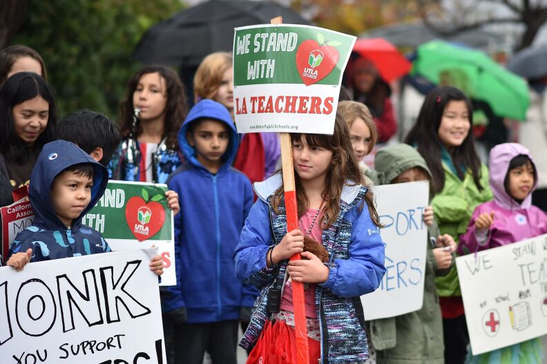 Students pose for a snapshot after walking the picket line with their teachers and parents on the third day of the teachers' strike, January 16, 2019, outside Dahlia Heights Elementary School in the Eagle Rock section of Los Angeles, California. - Teachers of the Los Angeles Unified School District (LAUSD), the second largest public school district in the United States, are striking for smaller class size, better school funding and higher teacher pay. (Photo by Robyn Beck / AFP)        (Photo credit should read ROBYN BECK/AFP/Getty Images)