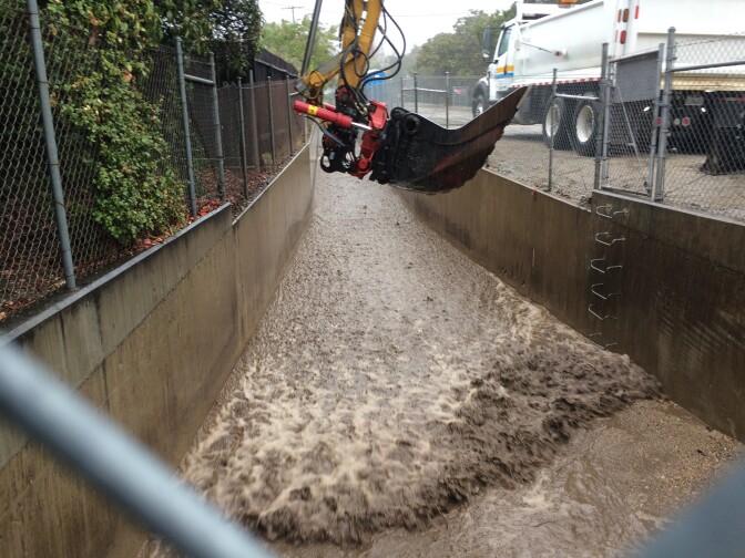 County workers use heavy equipment to break up debris flow in Glendora during a winter storm. 